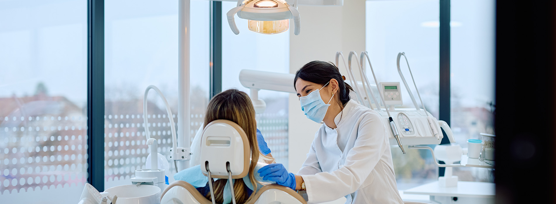 A dental hygienist is assisting a patient during a dental appointment.