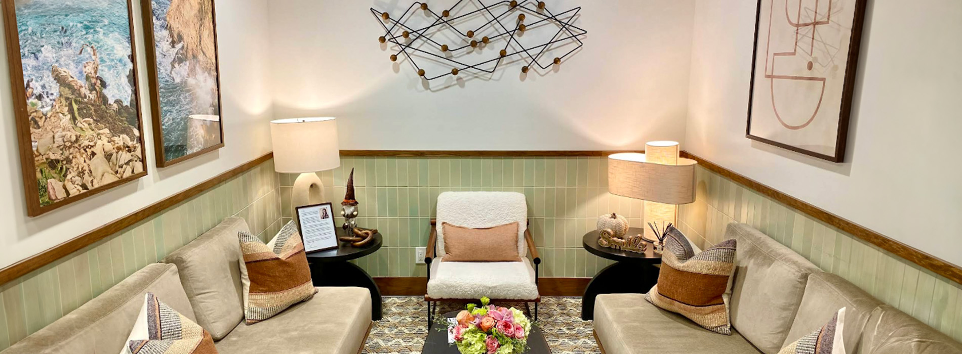 The image shows an interior space with a modern design, featuring a wall-mounted sculpture and contemporary furniture including a sofa and chairs.