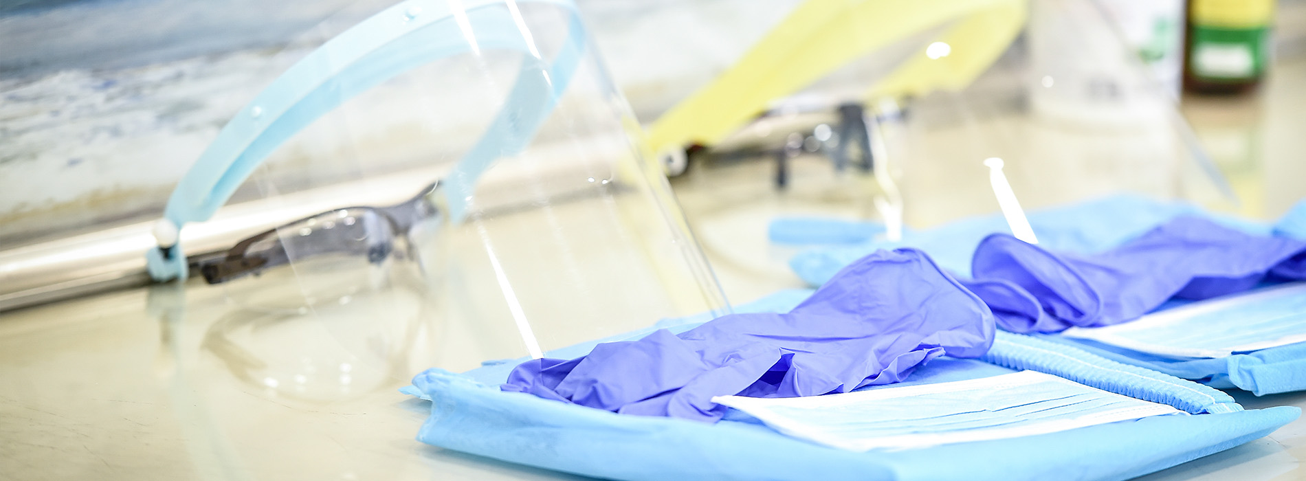 The image shows a collection of medical equipment on a table, with a prominent blue surgical gown.