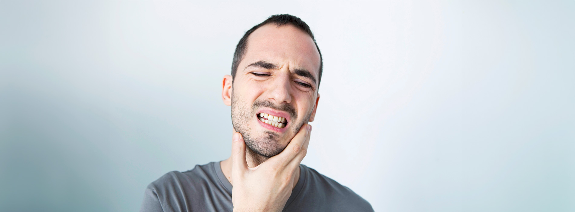 The image shows a man with a beard looking upwards with his mouth open, possibly expressing surprise or shock, against a plain background.